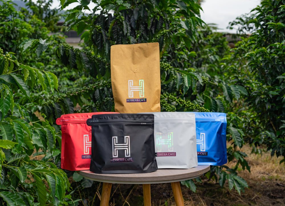 Empaques originales de Herrera Café frente al cultivo de café.